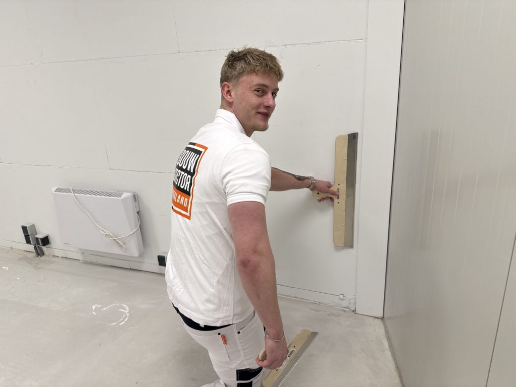 Stukadoor van Bouwsector Nederland zet met een spaan een gipsplaatwand glad